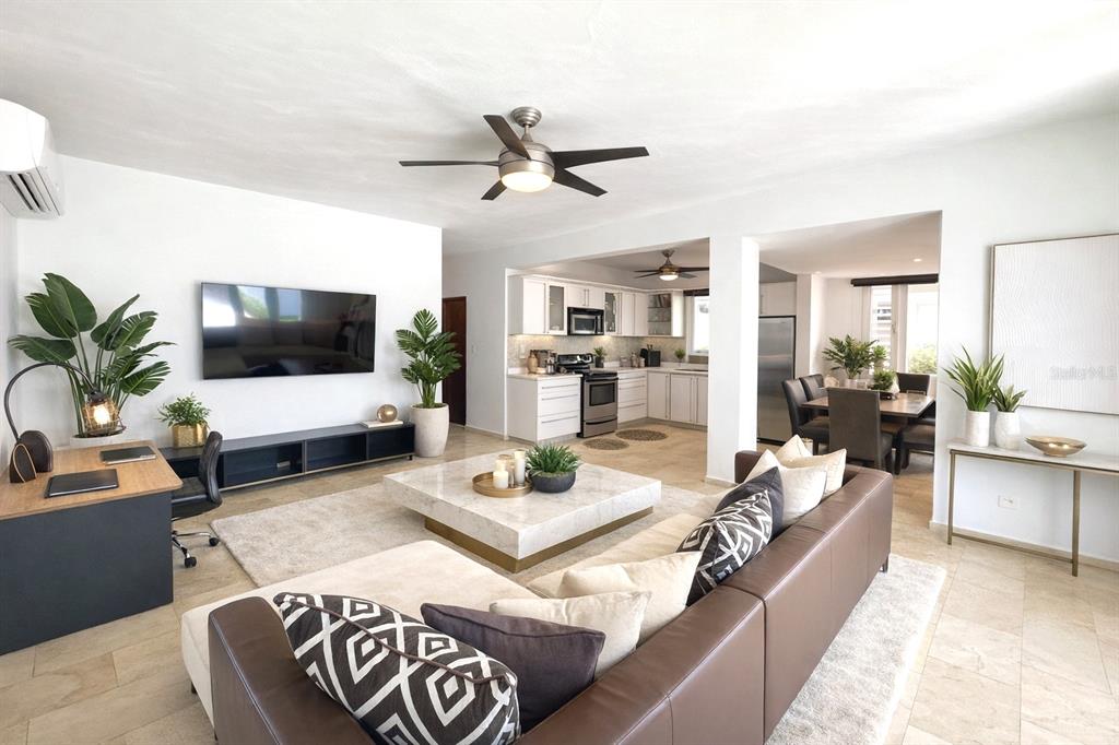 A living room with a brown leather sofa, marble coffee table, and an open kitchen — 17 GUERRERO NOBLE, SAN JUAN, PR