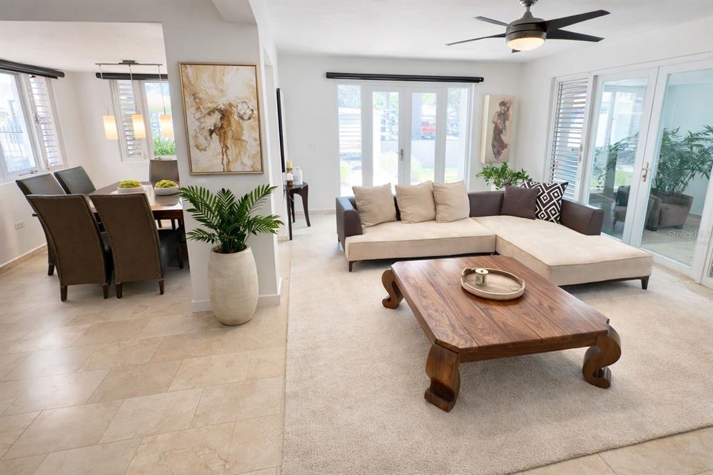 A living room with a sectional sofa and wooden coffee table next to a dining area — 17 GUERRERO NOBLE, SAN JUAN, PR