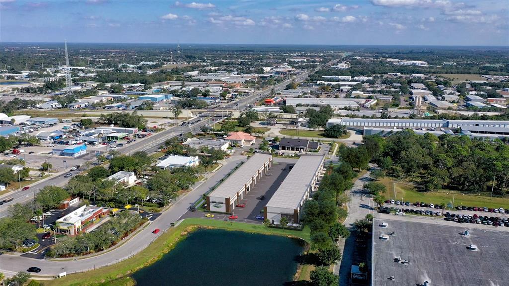 This is an aerial rendering of two commercial buildings situated next to a pond — 5864 DEREK AVENUE UNIT 1-2, SARASOTA, FL