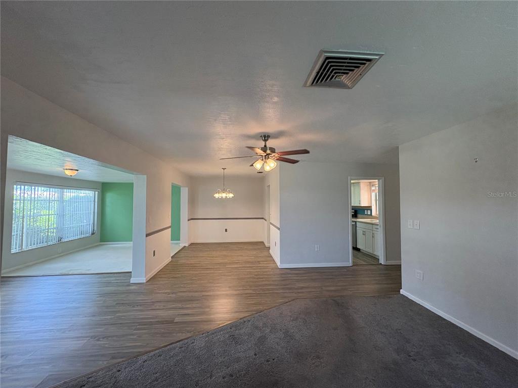 A living and dining area features wood-look flooring, gray walls, and a ceiling fan — 3276 BRUNSWICK LANE UNIT 705, SARASOTA, FL