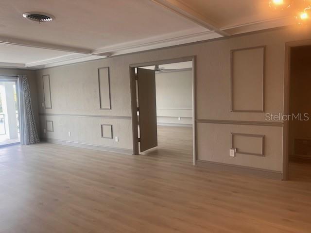 An interior room features light wood-look flooring, paneled walls, and a doorway leading to another room — 3717 46TH AVENUE S UNIT 11, ST PETERSBURG, FL