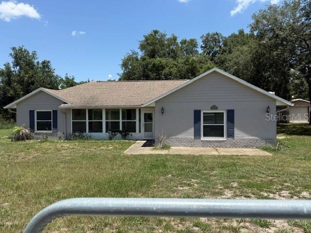 A single-story house with a gray exterior, a shingled roof, and a front concrete patio — 10930 TURNPIKE ROAD, CLERMONT, FL
