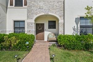 The exterior of a two-story house features a stone facade, a front door, and landscaping — 23080 SW 99th Ct, Cutler Bay FL 33190, CUTLER BAY, FL