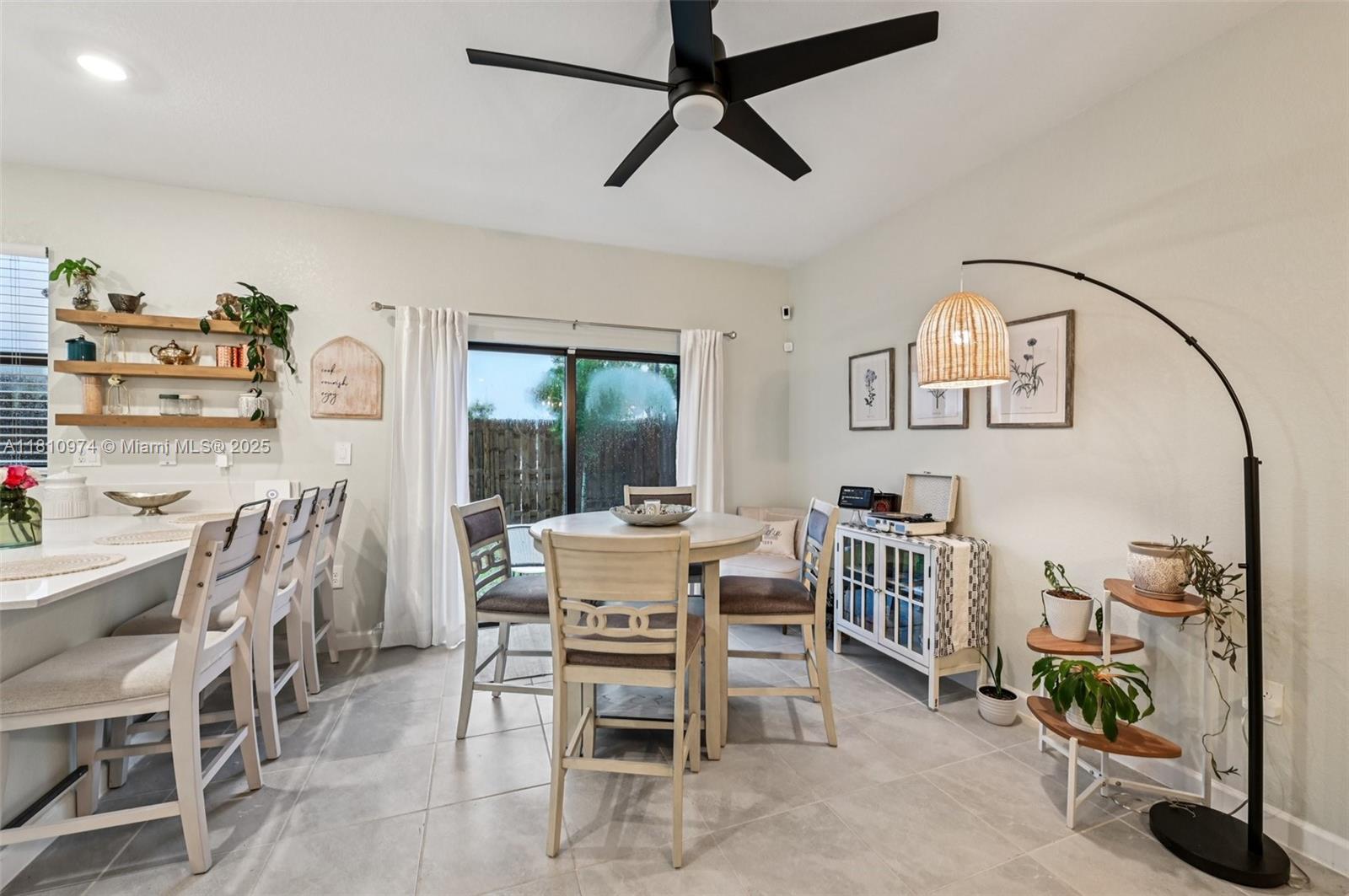 A dining area features a round table, chairs, a sideboard, and a tall floor lamp — 23080 SW 99th Ct, Cutler Bay FL 33190, CUTLER BAY, FL