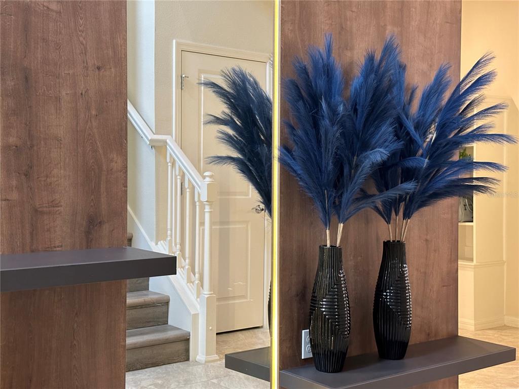 Two black vases with blue pampas grass sit on a shelf near a staircase — 4473 KAIPO ROAD, DAVENPORT, FL