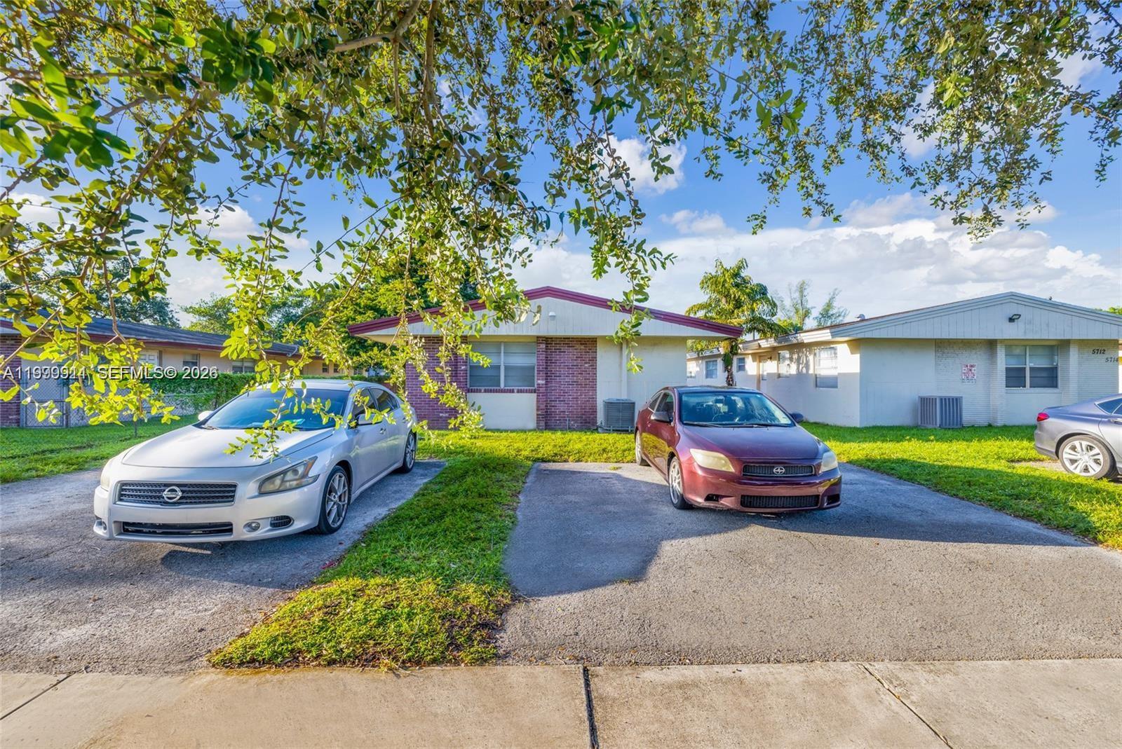 A single-story duplex with two cars parked in the driveway under a tree — 5706 Lincoln St, Hollywood FL 33021, HOLLYWOOD, FL