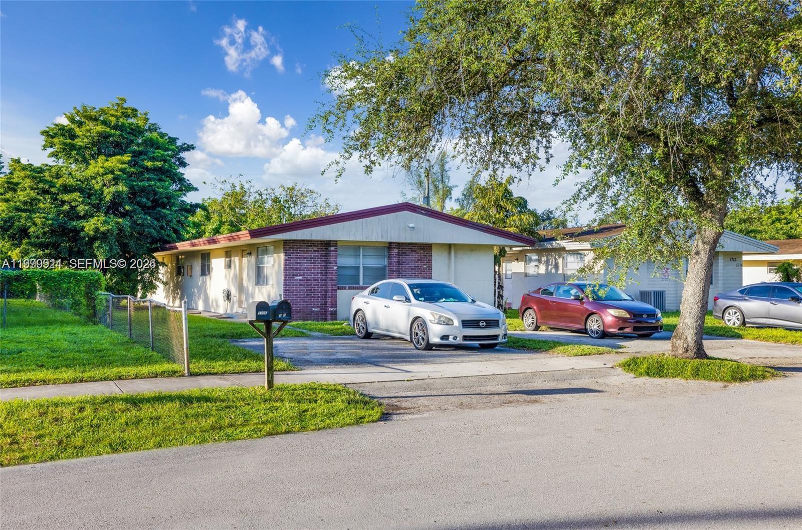 A single-story house with a brick facade and two cars parked in the driveway — 5706 Lincoln St, Hollywood FL 33021, HOLLYWOOD, FL