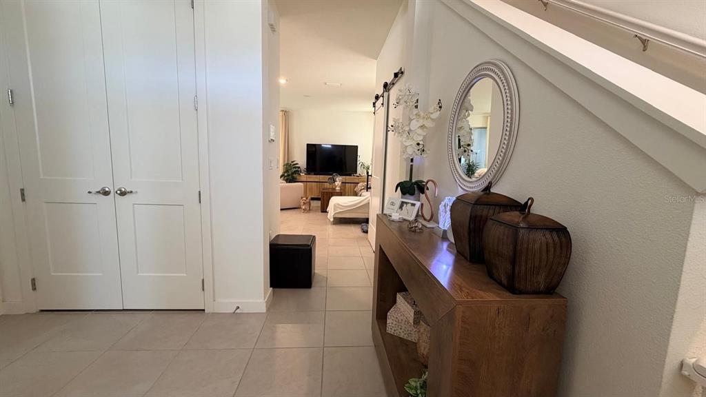 A hallway with a console table and mirror leads to a living room — 1978 EDUCATION STREET, ST CLOUD, FL