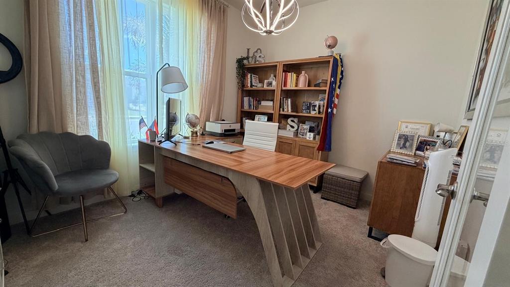 A home office features a wooden desk, a gray velvet chair, and built-in bookshelves — 1978 EDUCATION STREET, ST CLOUD, FL