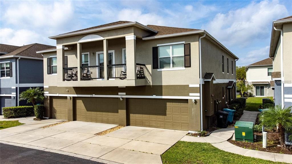 A two-story townhouse features a three-car garage and a second-floor balcony with black railings — 6538 S GOLDENROD ROAD UNIT 68C, ORLANDO, FL