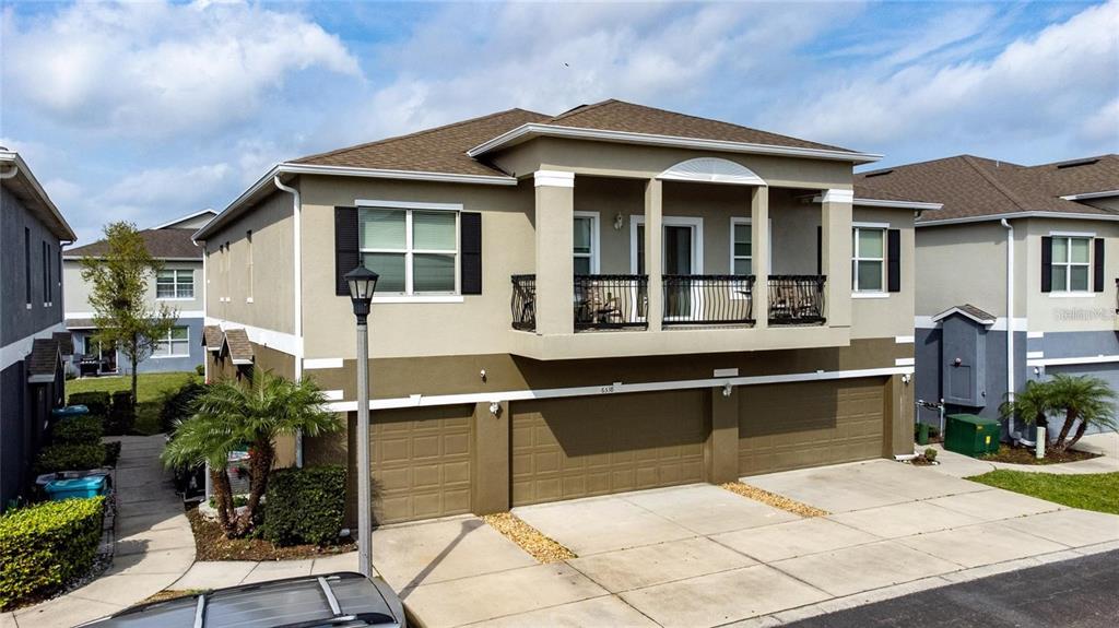 A two-story residential building features a three-car garage and a second-floor balcony with railings — 6538 S GOLDENROD ROAD UNIT 68C, ORLANDO, FL