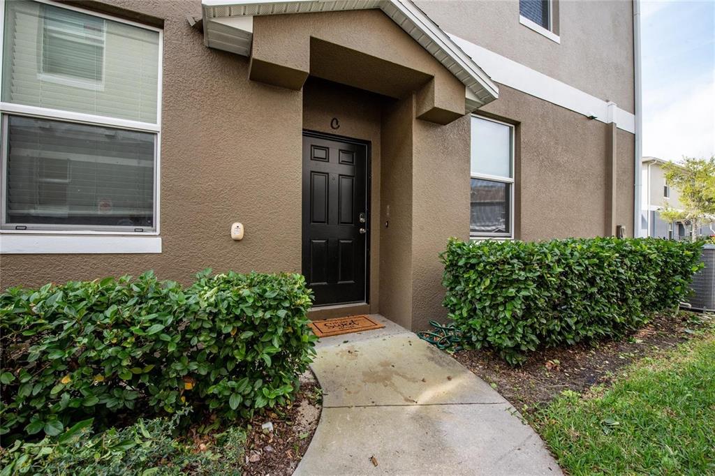 A brown stucco building exterior features a black front door under a small covered entryway — 6538 S GOLDENROD ROAD UNIT 68C, ORLANDO, FL