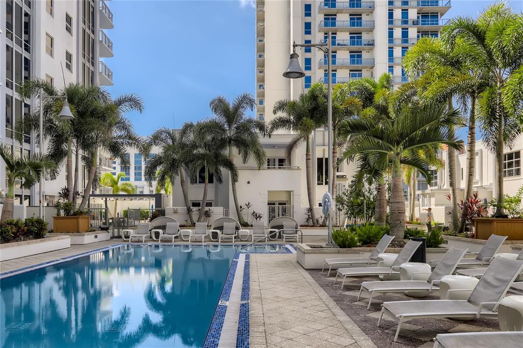 A swimming pool surrounded by lounge chairs and palm trees at a multi-story apartment building — 415-1 E PINE STREET, ORLANDO, FL