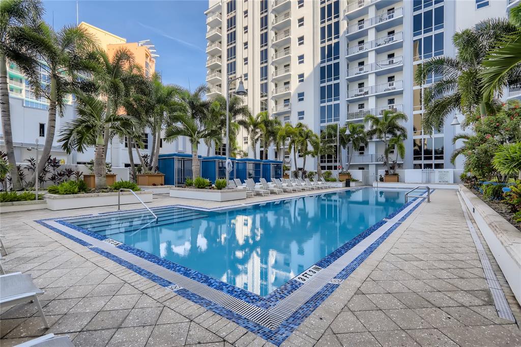 A swimming pool with blue tile trim sits on a patio surrounded by palm trees — 415-1 E PINE STREET, ORLANDO, FL