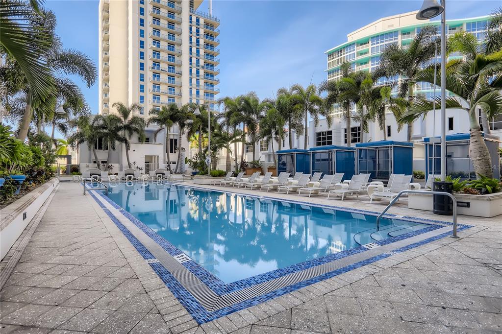 A rectangular swimming pool is surrounded by lounge chairs, palm trees, and high-rise buildings — 415-1 E PINE STREET, ORLANDO, FL