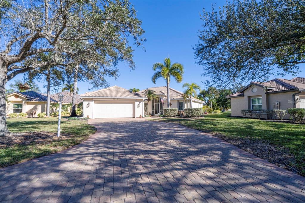 A single-story house with a paved driveway, a two-car garage, and palm trees — 4115 CAPE COLE BOULEVARD, PUNTA GORDA, FL