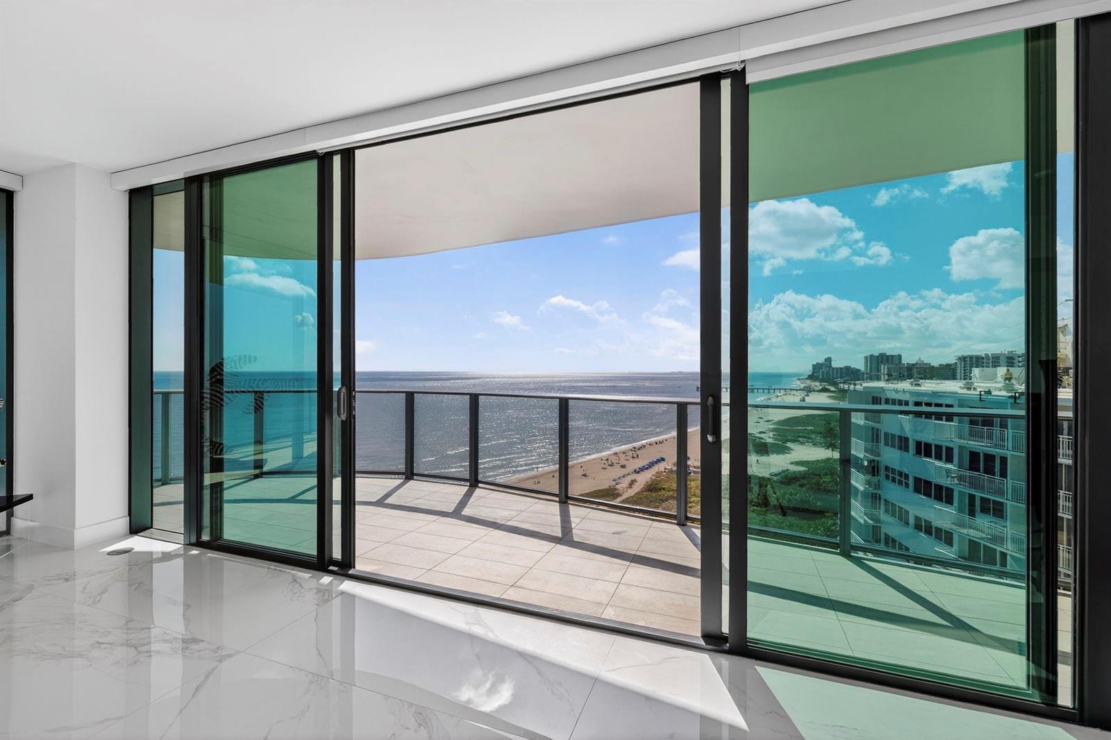 A room with white marble floors features large sliding glass doors opening to a balcony — 730 N Ocean Boulevard # 1204, Pompano Beach FL 33062, POMPANO BEACH, FL