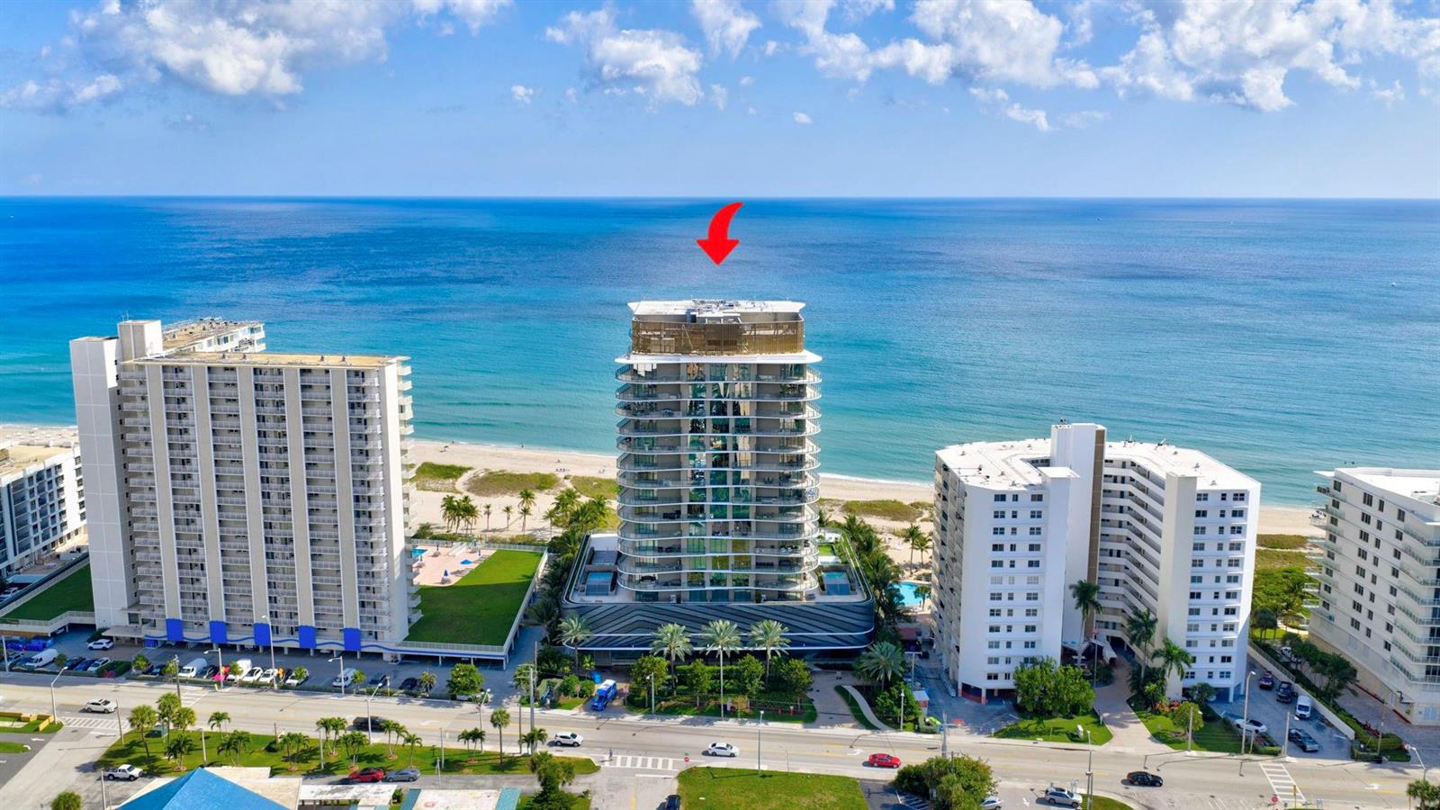 An aerial view of a modern beachfront high-rise condominium building with a red arrow above — 730 N Ocean Boulevard # 1204, Pompano Beach FL 33062, POMPANO BEACH, FL