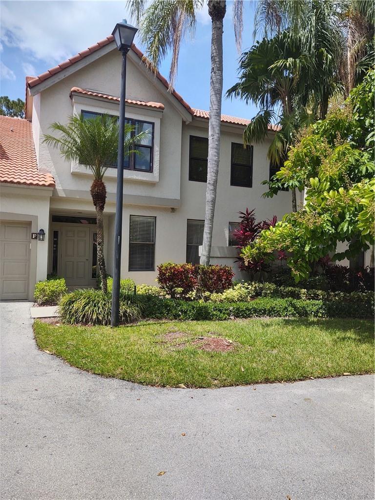 A two-story stucco townhouse with a tile roof, palm trees, and a paved driveway — 5801 Coach House Circle # B, Boca Raton FL 33486, BOCA RATON, FL