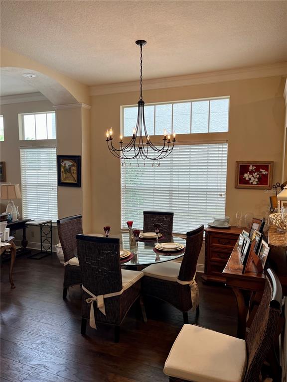 A dining room features a glass-topped table, wicker chairs, and a large iron chandelier — 8444 FOXWORTH CIRCLE UNIT 48, ORLANDO, FL