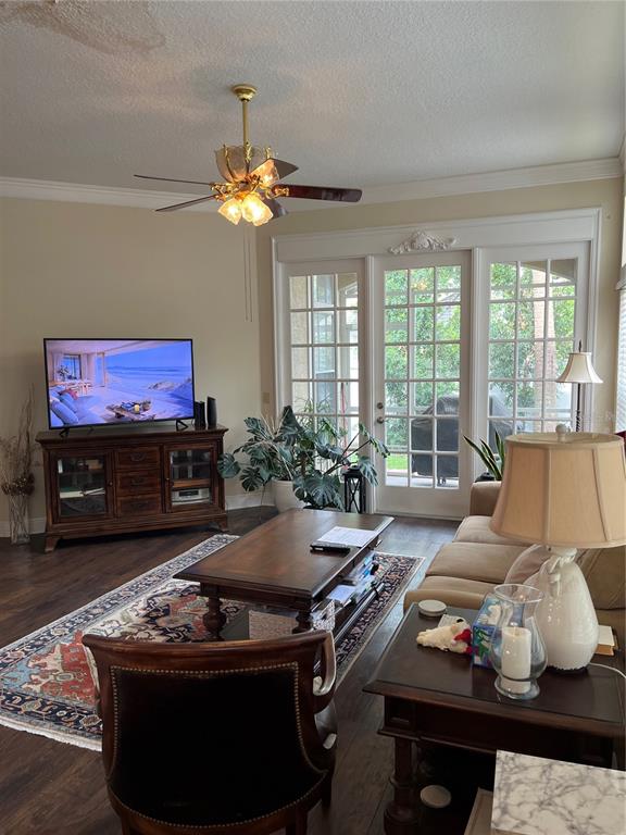 A dining room features a glass-topped table, wicker chairs, and a large iron chandelier — 8444 FOXWORTH CIRCLE UNIT 48, ORLANDO, FL