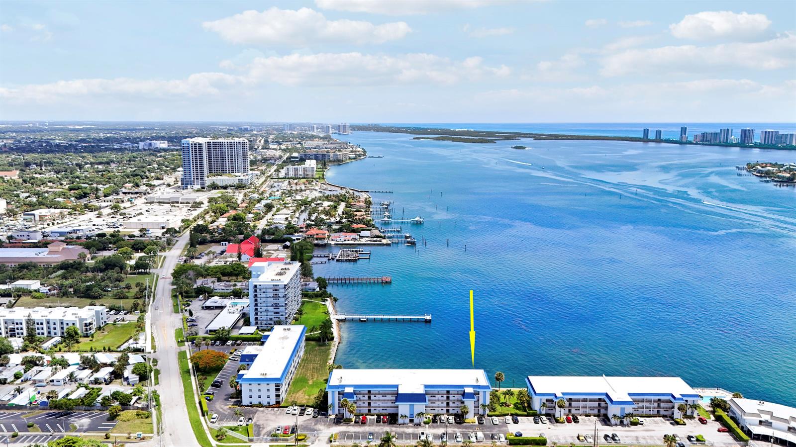 An aerial view shows a waterfront apartment complex with a yellow arrow pointing downward — 410 Wilma Circle # 308, Riviera Beach FL 33404, RIVIERA BEACH, FL