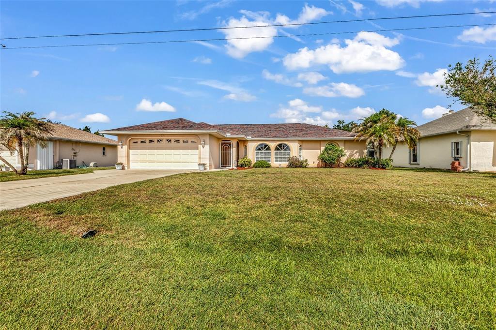 A single-story suburban house with a two-car garage and a large front lawn — 29 SEASONS DRIVE, PUNTA GORDA, FL