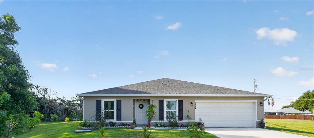 A single-story house with a gray exterior, dark shutters, and a two-car garage — 2274 SE POWELL COURT, PORT ST LUCIE, FL