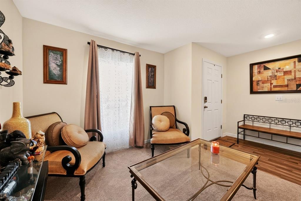 A living room features two armchairs, a glass coffee table, and a metal bench — 2274 SE POWELL COURT, PORT ST LUCIE, FL