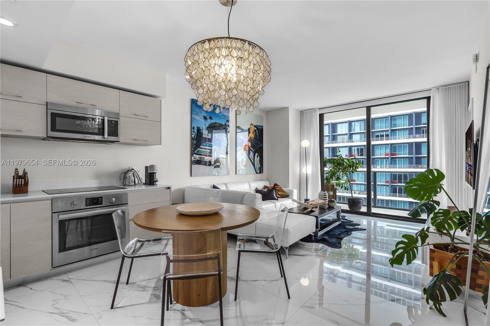 A modern open-concept living and dining area features light wood cabinetry and marble-look tile flooring — 1300 S Miami Ave # 2508, Miami FL 33130, MIAMI, FL