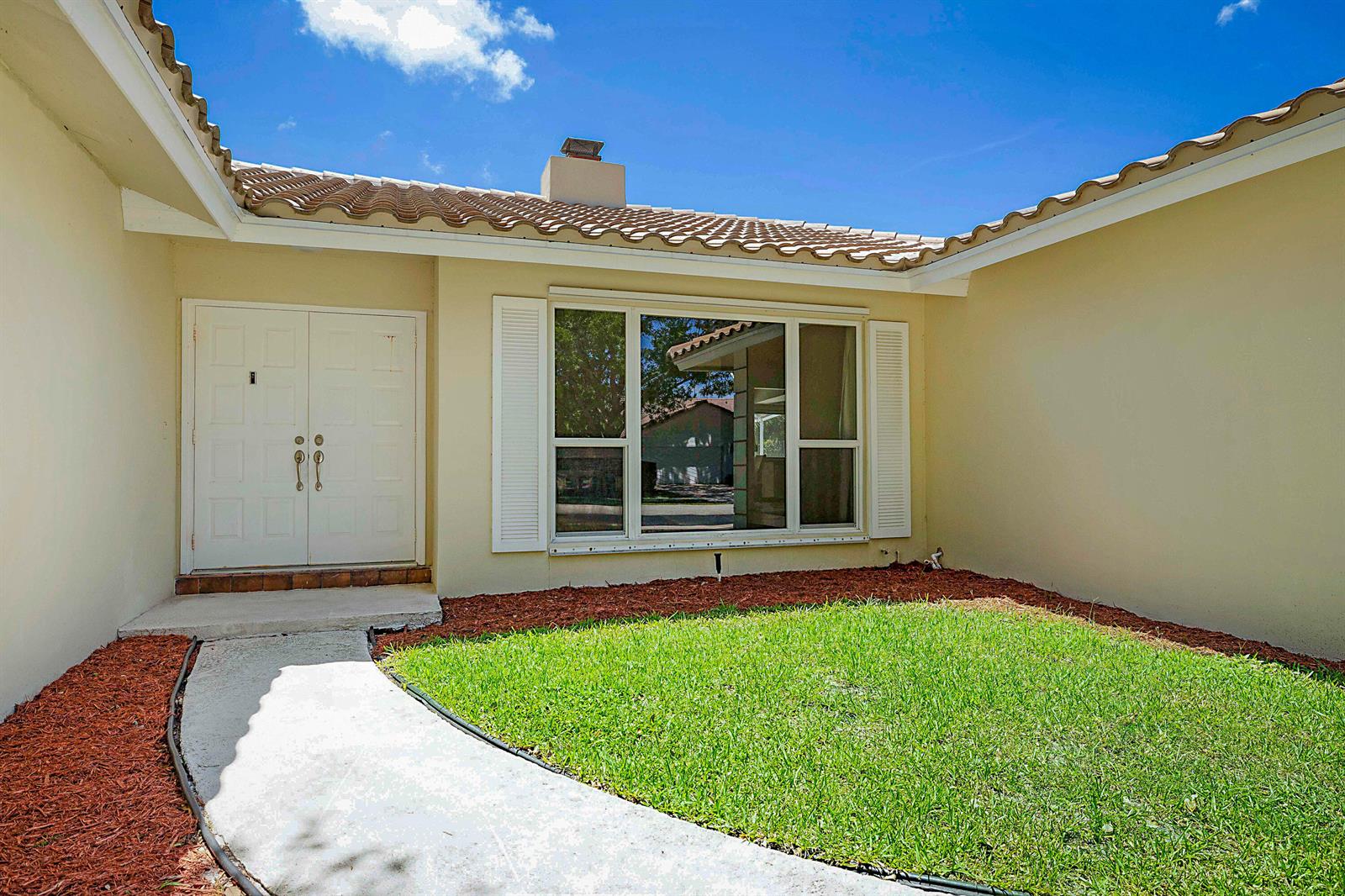 The exterior view shows a white double front door and a large window with shutters — 20869 Sonrisa Way, Boca Raton FL 33433, BOCA RATON, FL