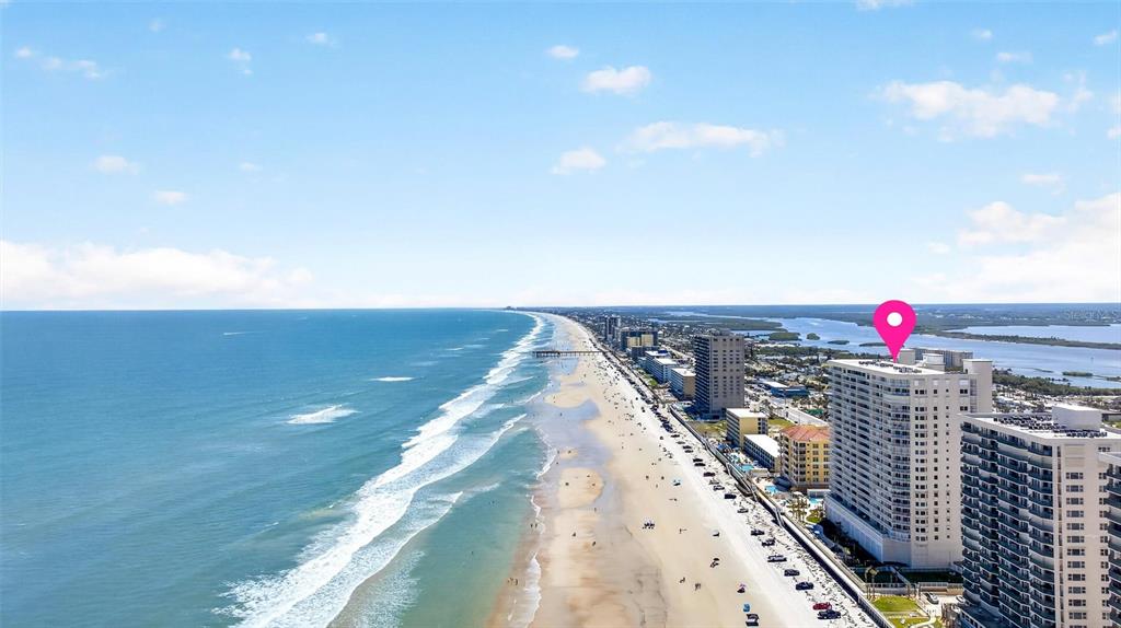 An aerial view shows a high-rise building on a sandy beach along the ocean — 3333 S ATLANTIC AVENUE UNIT 2202, DAYTONA BEACH, FL