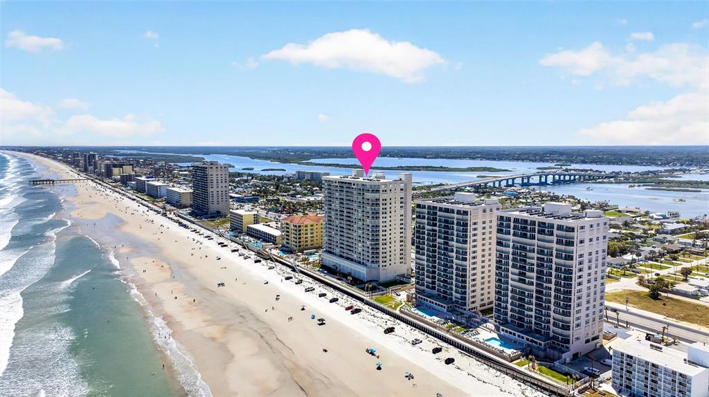 An aerial view shows several high-rise beachfront condominiums along a sandy coastline — 3333 S ATLANTIC AVENUE UNIT 2202, DAYTONA BEACH, FL