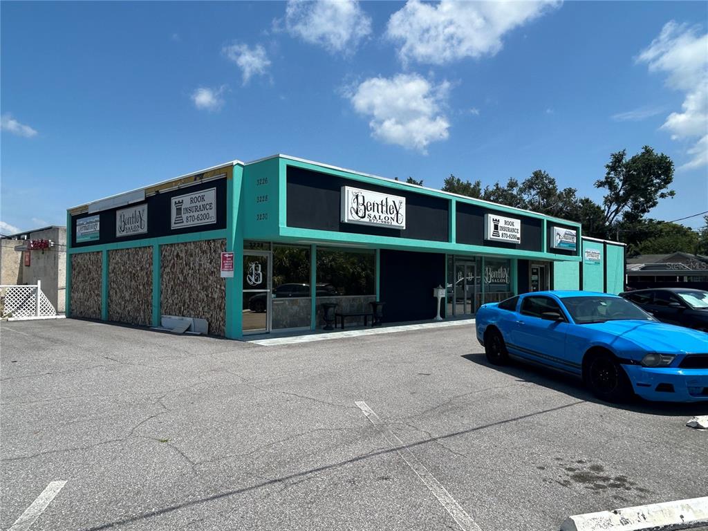 A single-story commercial building with teal trim and a parking lot in front — 3226 W KENNEDY BOULEVARD, TAMPA, FL