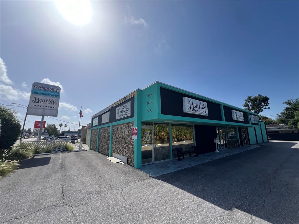 A commercial building with a teal and black exterior features a salon and insurance office — 3226 W KENNEDY BOULEVARD, TAMPA, FL