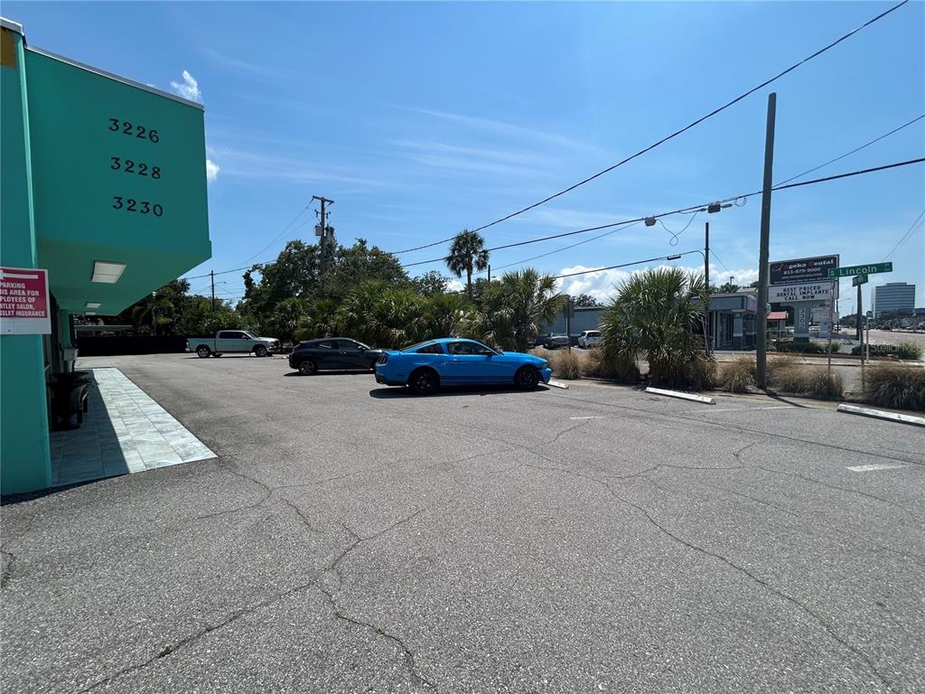 A parking lot sits in front of a teal building with address numbers displayed — 3226 W KENNEDY BOULEVARD, TAMPA, FL