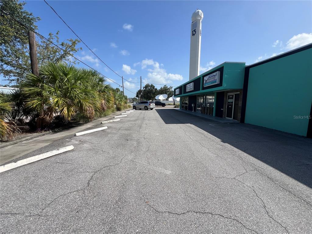 A teal commercial building with a tall white tower stands beside a paved parking lot — 3226 W KENNEDY BOULEVARD, TAMPA, FL