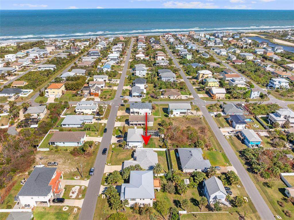 An aerial view shows a coastal neighborhood with a red arrow pointing to a house — 20 MOODY DRIVE, PALM COAST, FL