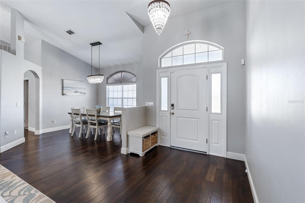 A dining area and entryway feature dark wood floors, a crystal chandelier, and white doors — 20 MOODY DRIVE, PALM COAST, FL