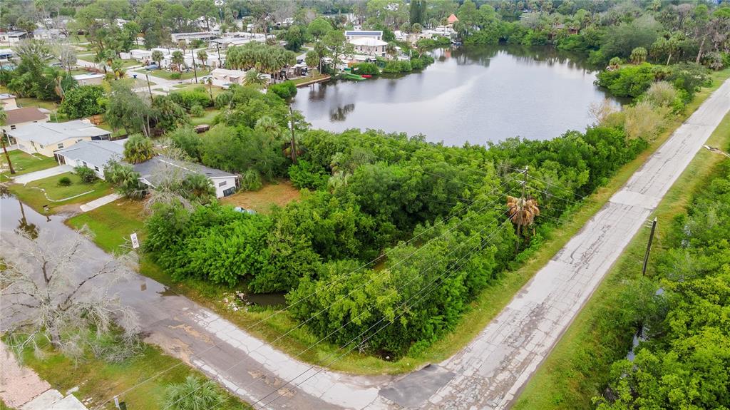An aerial view shows a wooded vacant lot situated between a residential street and water — 4935 LARGO TERRACE, NEW PORT RICHEY, FL