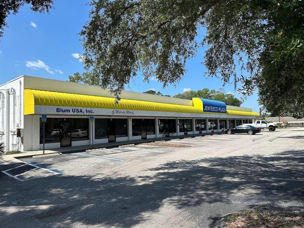 A single-story commercial strip mall with a yellow awning and parking lot in front — 821 NE 36TH TERRACE UNIT 7/8/9, OCALA, FL