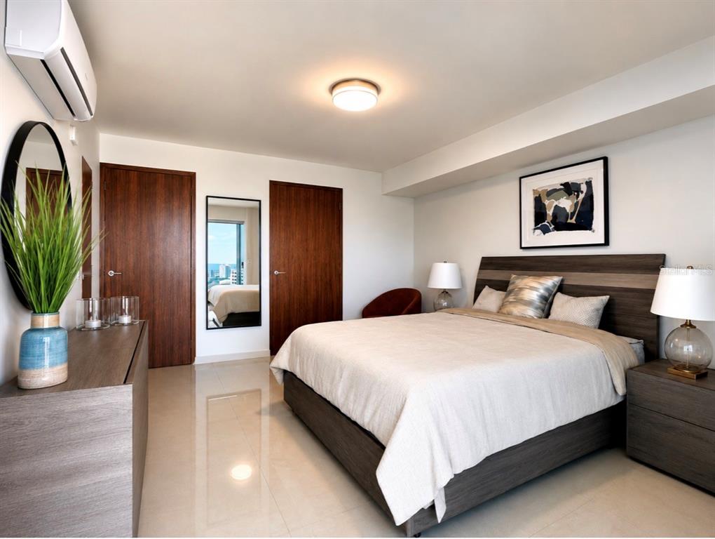 A bedroom features a bed with a wooden headboard, tiled floors, and two wooden doors — 48 LUIS MUÑOZ RIVERA UNIT 2202, SAN JUAN, PR