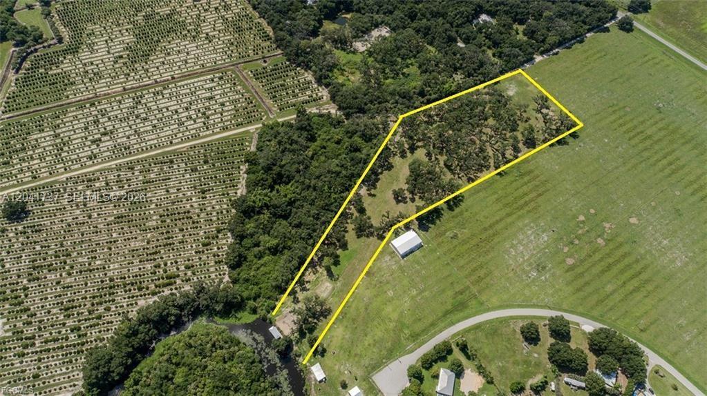 An aerial view shows a plot of land outlined in yellow featuring trees and structures — 5247 County Road 78, La Belle FL 33935, LA BELLE, FL