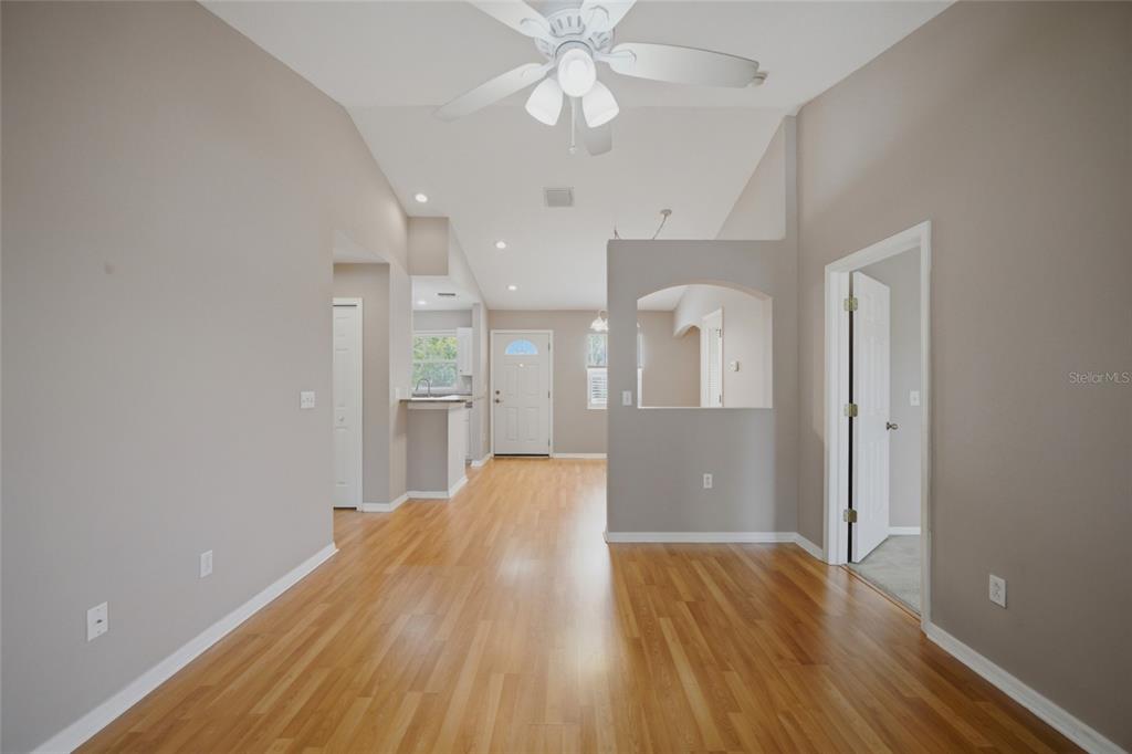 An interior view of a living area with hardwood floors, a ceiling fan, and arched wall — 9019 COCHISE LANE UNIT 201, PORT RICHEY, FL