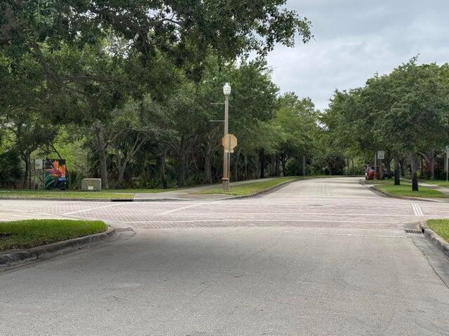 A paved intersection is surrounded by lush green trees and landscaping on a cloudy day — 2131 SE Destin Drive, FL 34952, FL