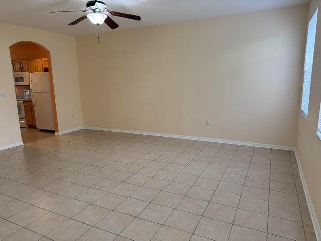 An empty room with beige walls, tile flooring, and a ceiling fan — 2131 SE Destin Drive, FL 34952, FL