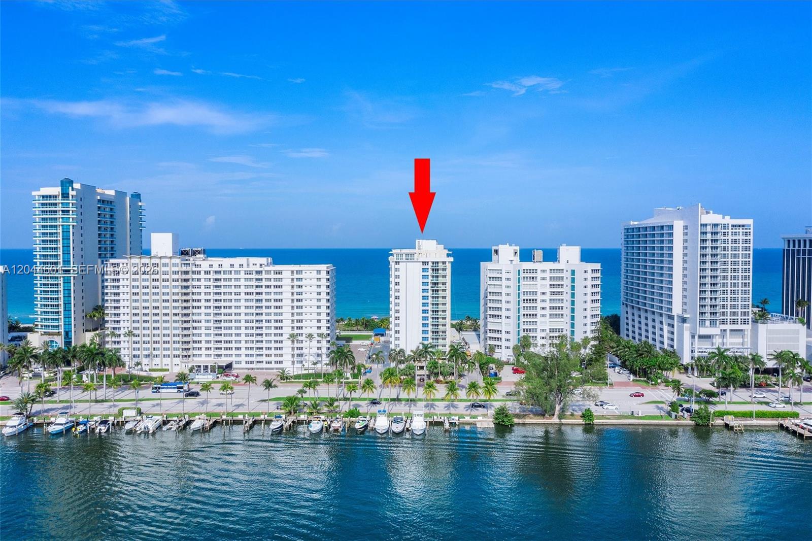 An aerial view shows a tall residential building marked by a red arrow near water — 5001 Collins Ave # 9H, Miami Beach FL 33140, MIAMI BEACH, FL