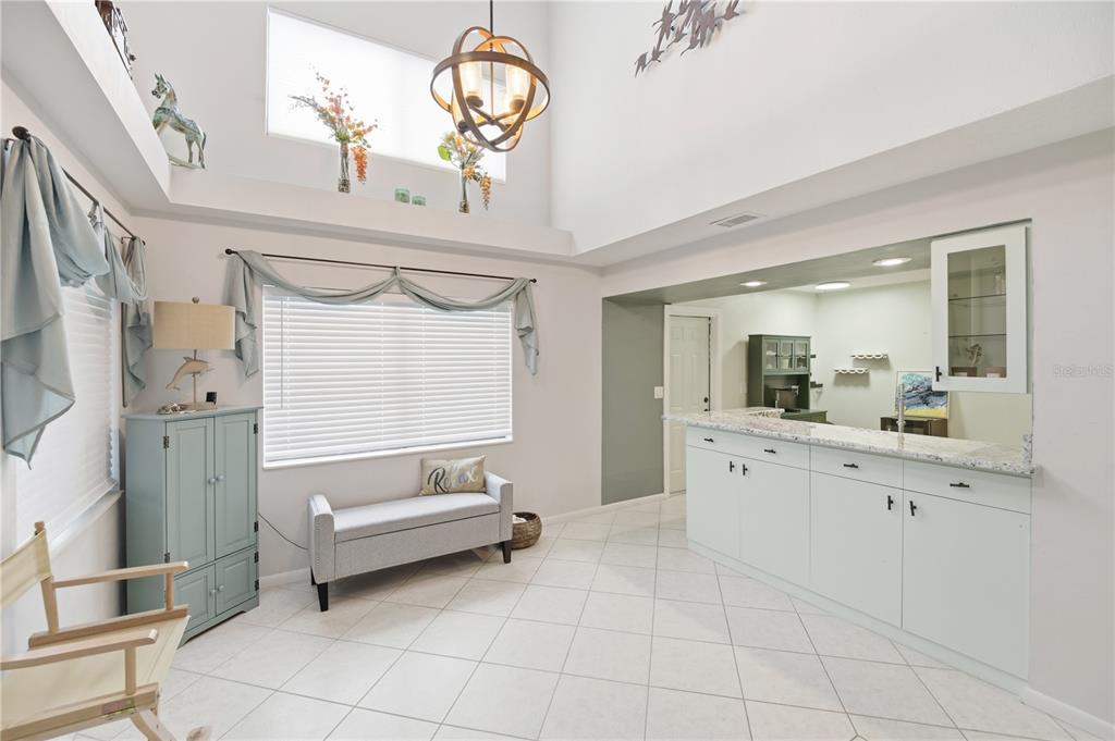 A room with high ceilings, a wet bar, a window with blinds, and tile flooring — 56 LAKE FOREST PLACE, PALM COAST, FL