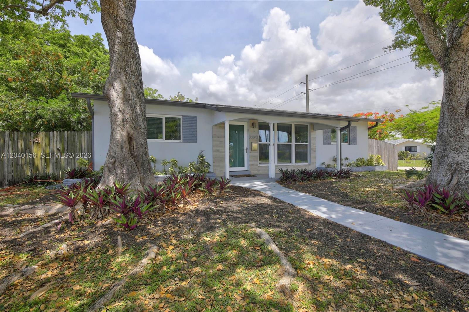 A single-story house with a light-colored exterior, a front porch, and large mature trees — 2220 N 40th Ave, Hollywood FL 33021, HOLLYWOOD, FL