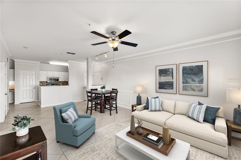 An open-concept living and dining area features tile flooring, a ceiling fan, and neutral decor — 4305 BAYSIDE VILLAGE DRIVE UNIT 202, TAMPA, FL